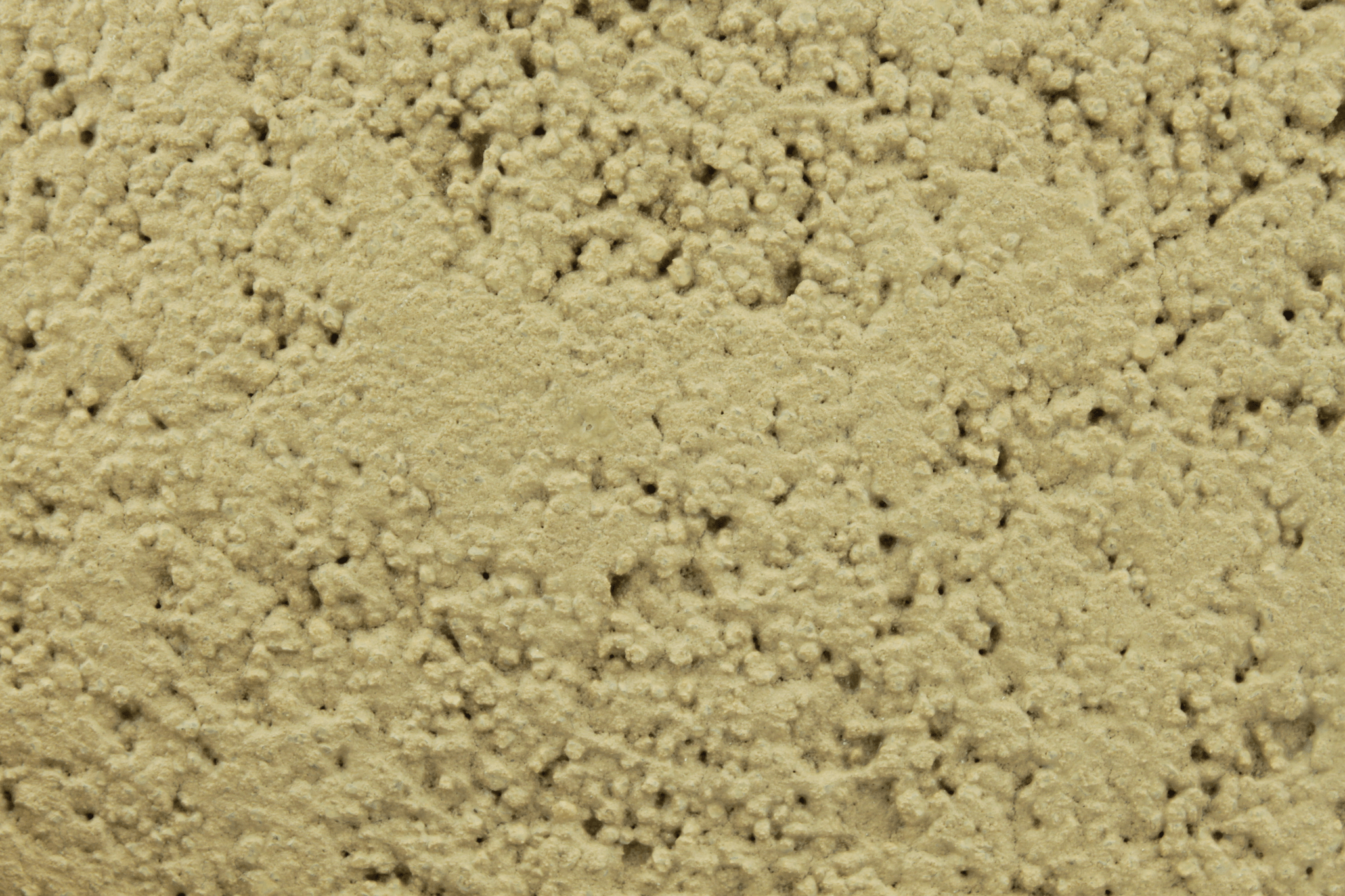 macro texture of warm ochre italian aggregate plaster, golden mustard mineral grains