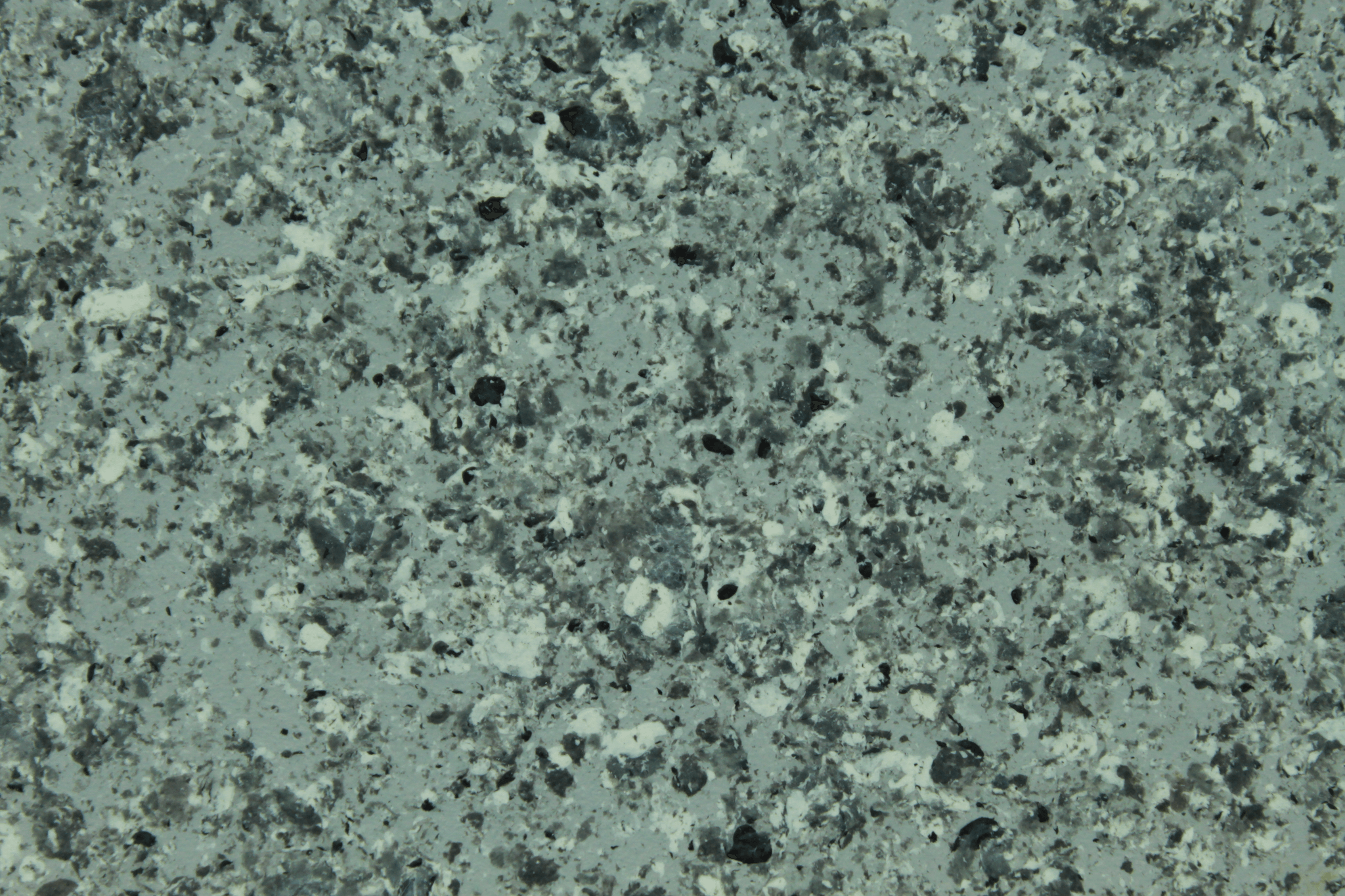 macro texture of emerald green granite finish with dark crystalline stone flakes